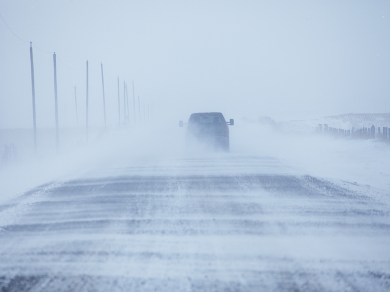 truck driving on road with blowing snow - living in dufferin county